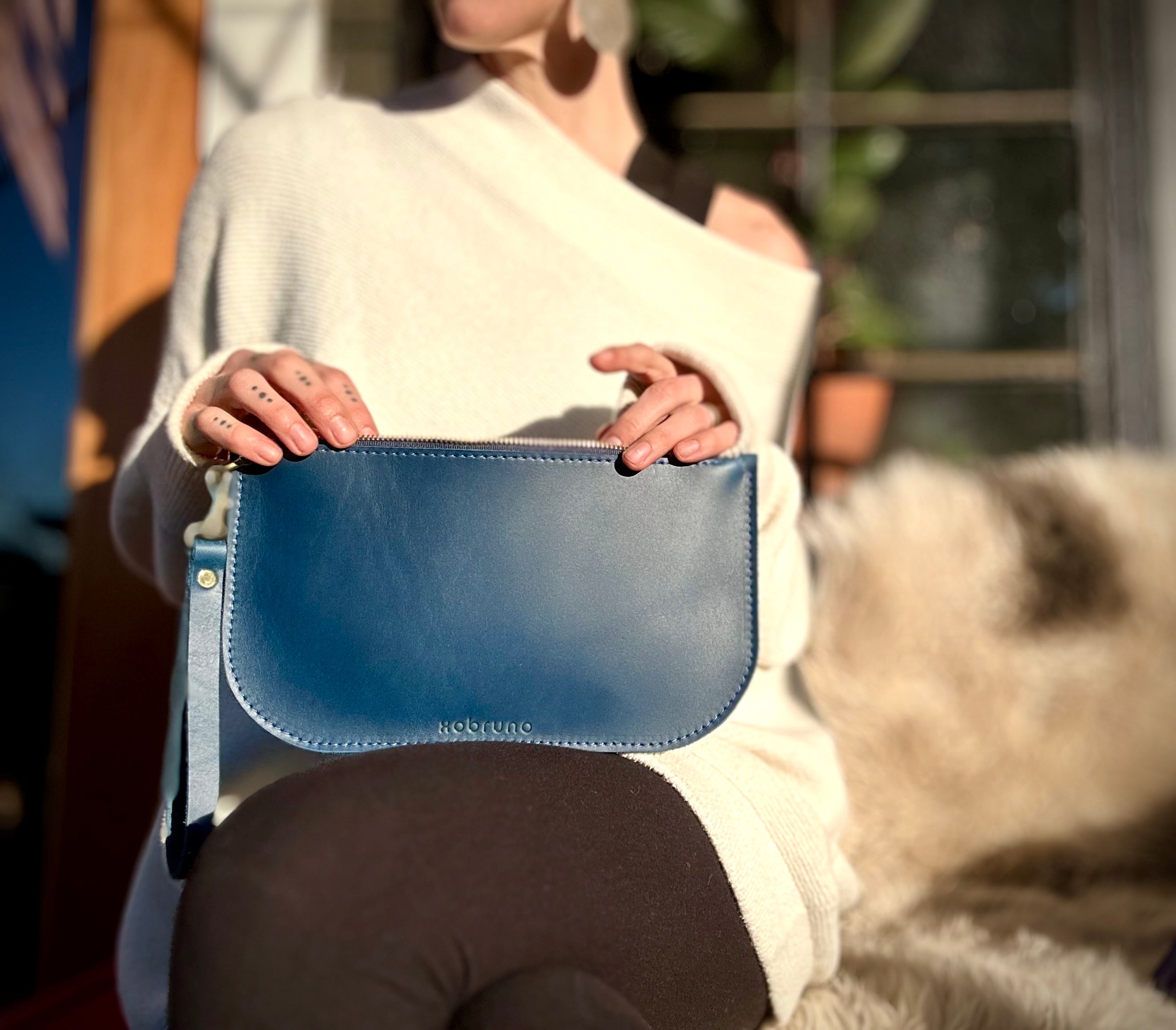 woman holding xobruno blue flat zip pouch